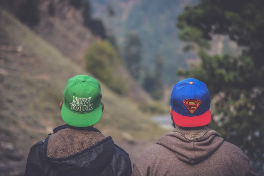 Two men outside wearing fitted baseball caps