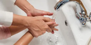 Two people washing their hands in a basin