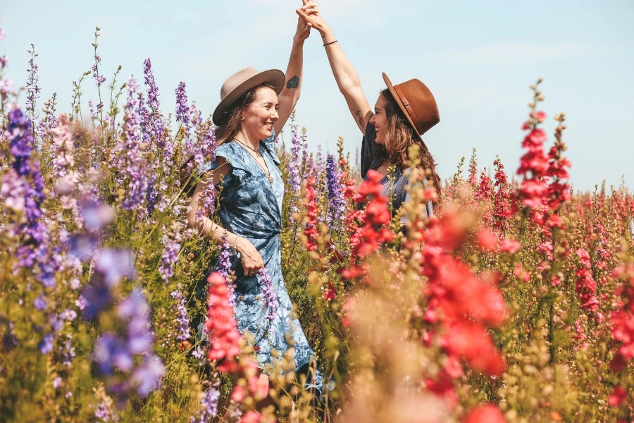 Dos mujeres bailando en un campo de flores.