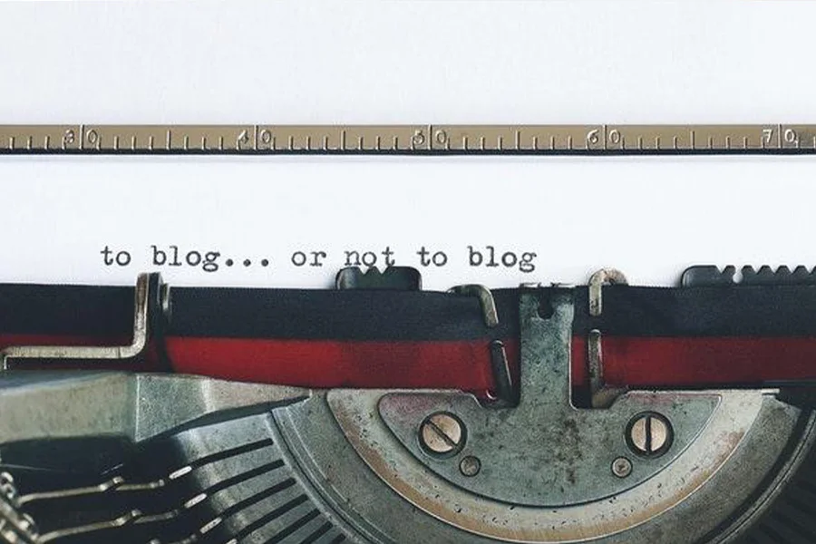 Vintage typewriter with letters on white paper about blogs