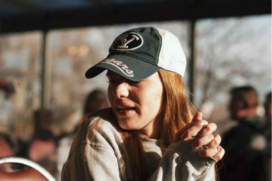 Mujer con gorra de béisbol bicolor gris y blanca