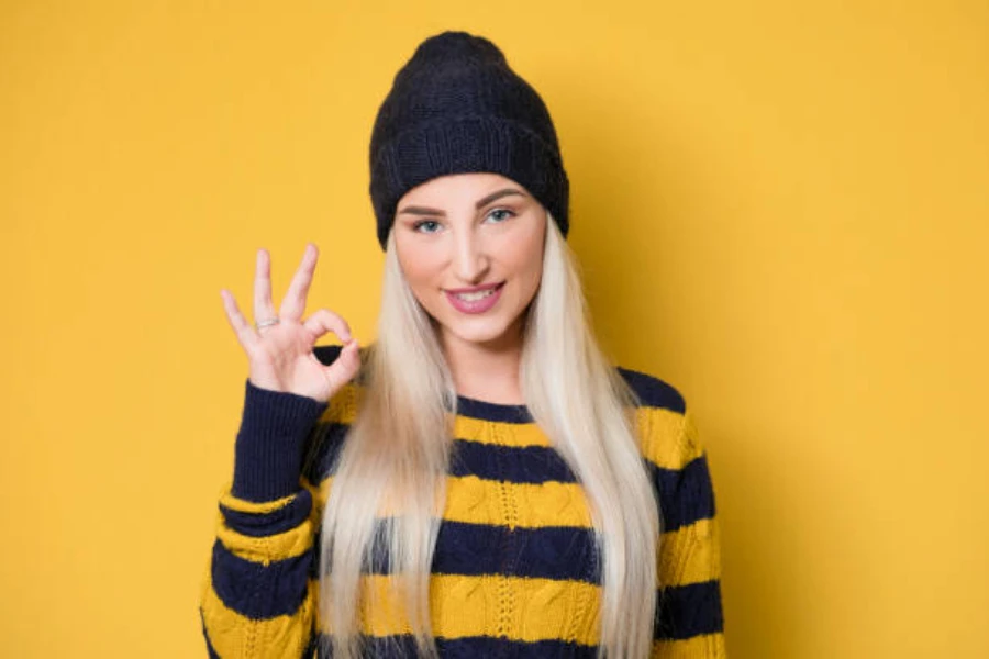 Woman in yellow and black striped sweater and black beanie
