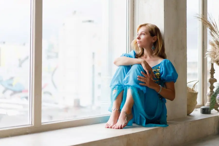 Femme assise sur un rebord de fenêtre