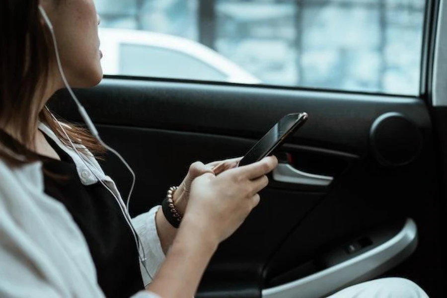 Mulher usando um telefone celular em um carro