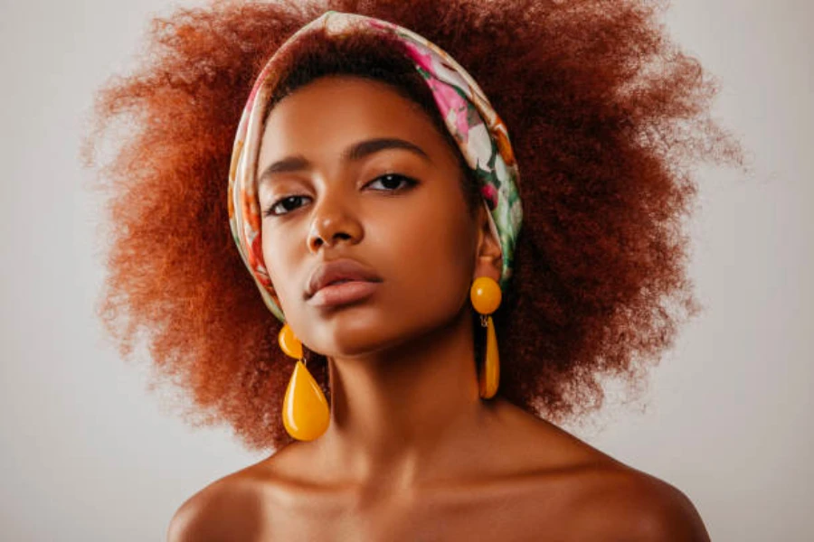 Femme portant un foulard et des boucles d'oreilles orange