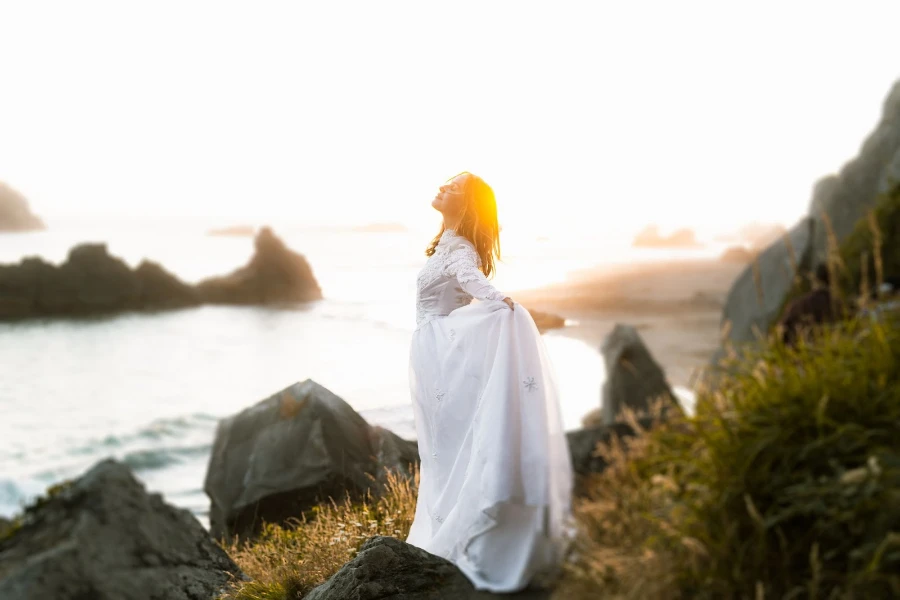 Woman wearing a white gown overlooking a lake