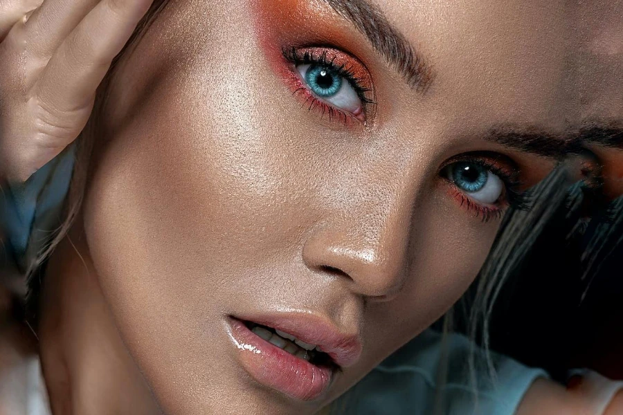 Mujer con maquillaje de ojos duocromático naranja