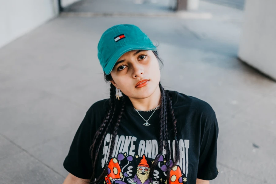 Femme portant une casquette de baseball en denim sarcelle avec logo brodé