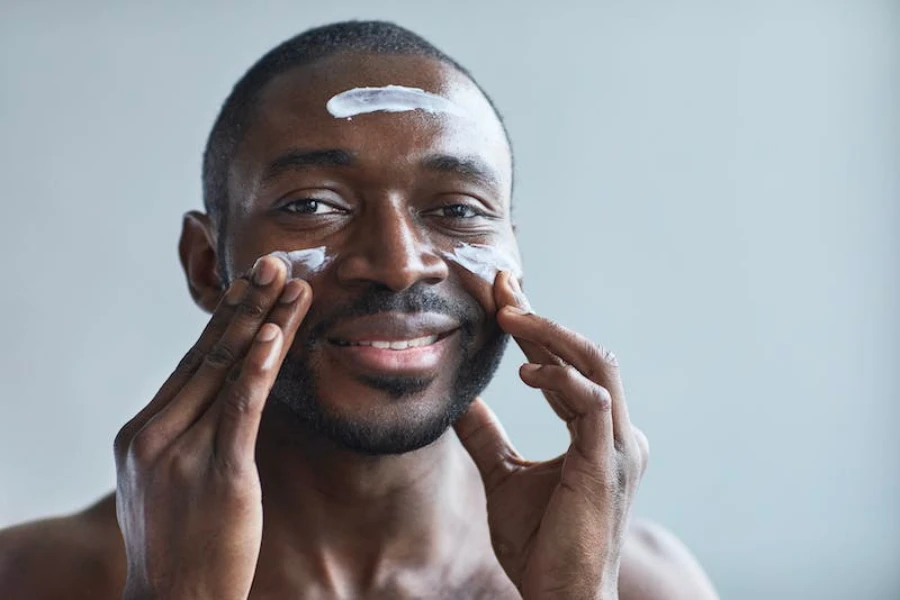 Un hombre aplicándose crema hidratante en la cara