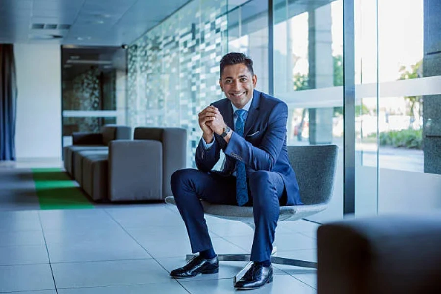 A man in a suit sitting in an office lobby