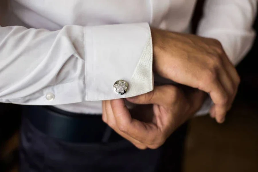 A man wearing a shirt with a metallic cufflink