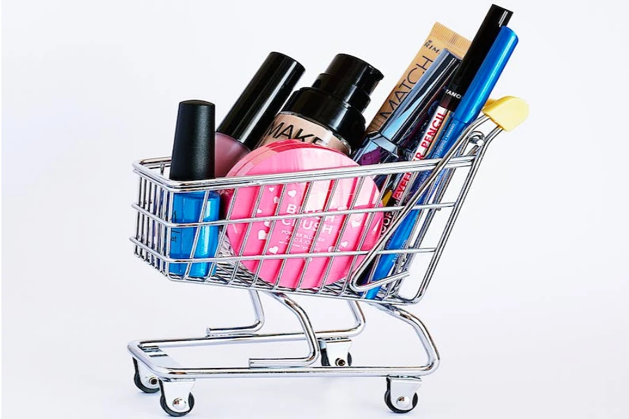 A miniature shopping cart filled with beauty products