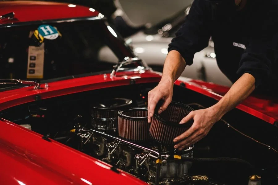 A person changing an air filter in a car