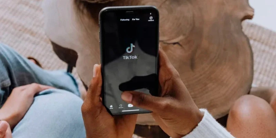 A person holding a phone with the TikTok application open