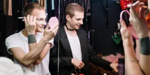 A picture of two men applying makeup