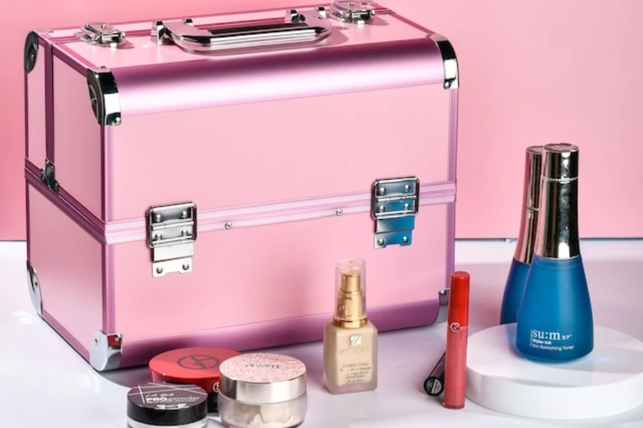A pink case next to a bunch of cosmetics