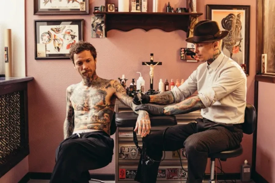 A tattoo artist wearing a classic fedora for a timeless masculine look