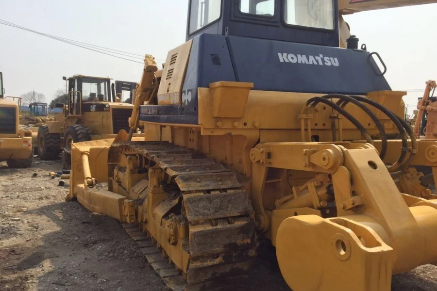 a used Komatsu bulldozer next to Caterpillar machines