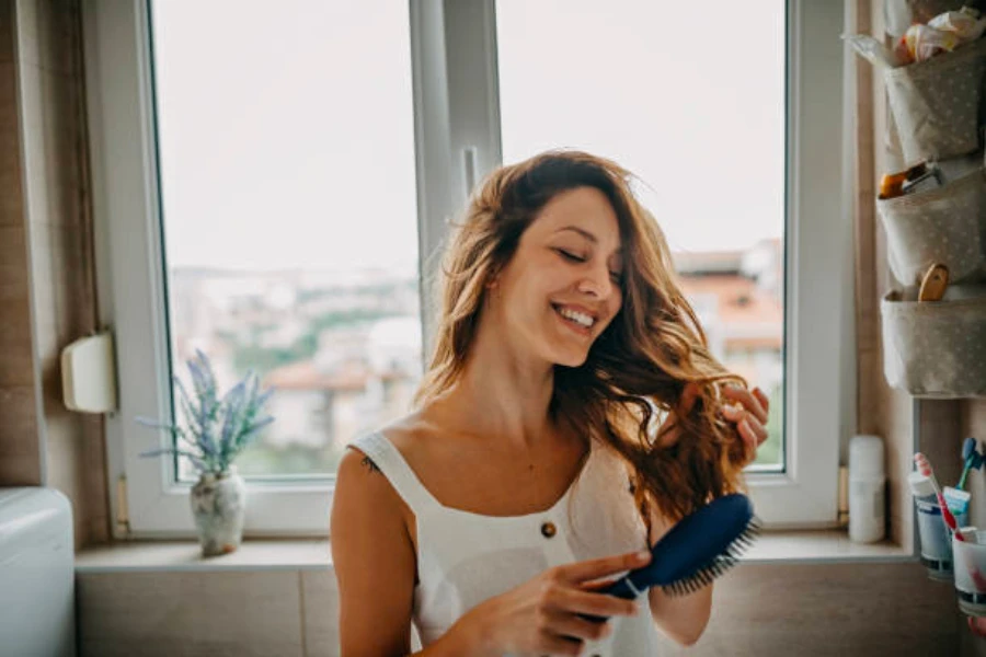 A woman brushing her long curly hair in the bathroom