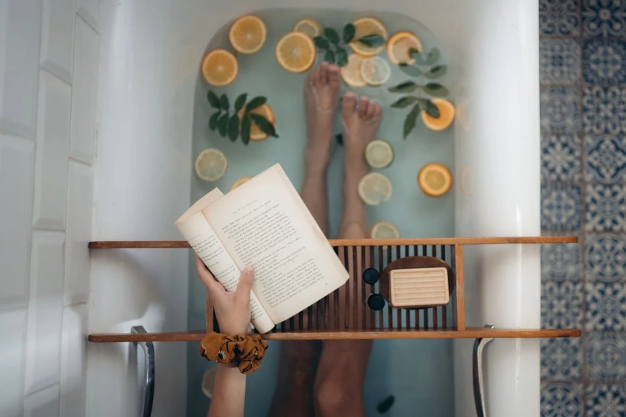 A woman taking a bath and reading a book