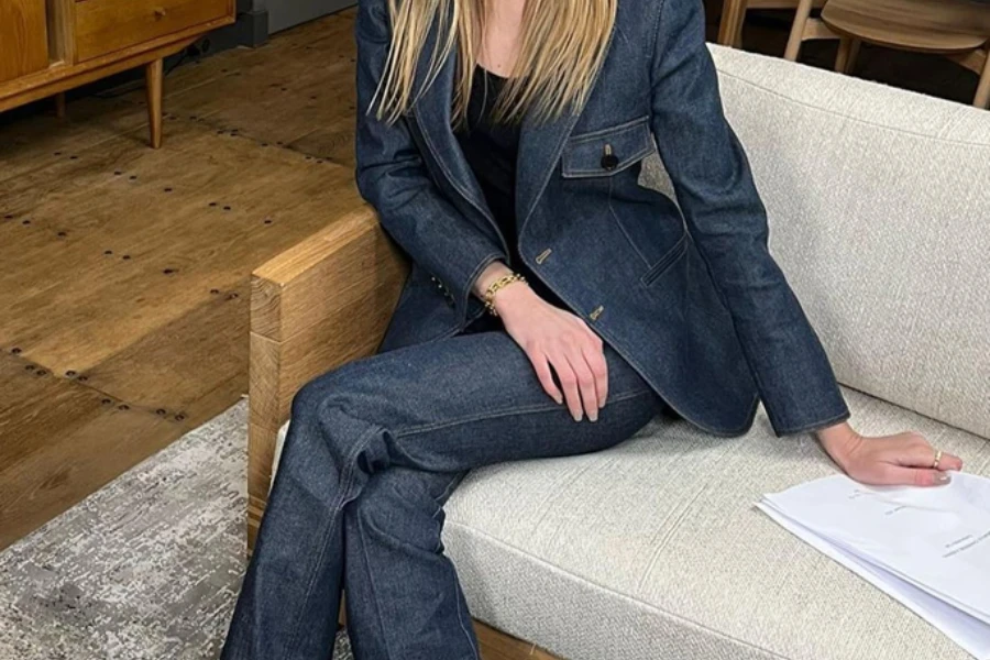 A young lady in denim suit sitting on a couch