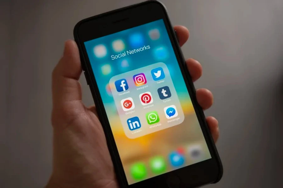 An iPhone with social media apps displayed on the screen