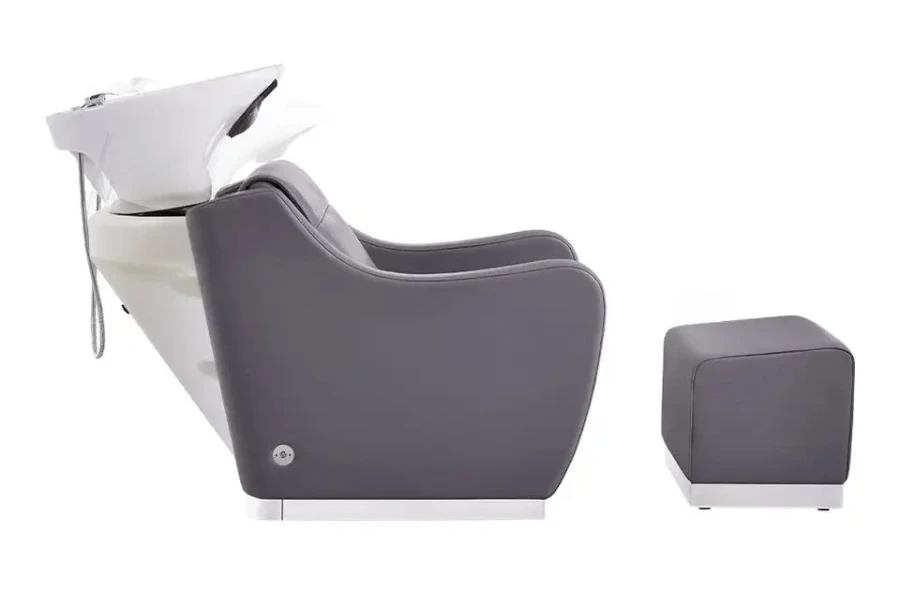 Grey shampoo chair with sink attached and foot rest