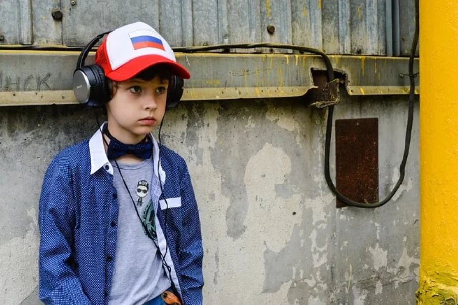 Kid wearing red and blue baseball cap with headphones