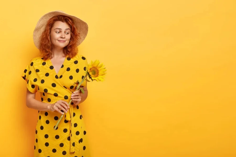 Lady in a yellow dress holding a sunflower