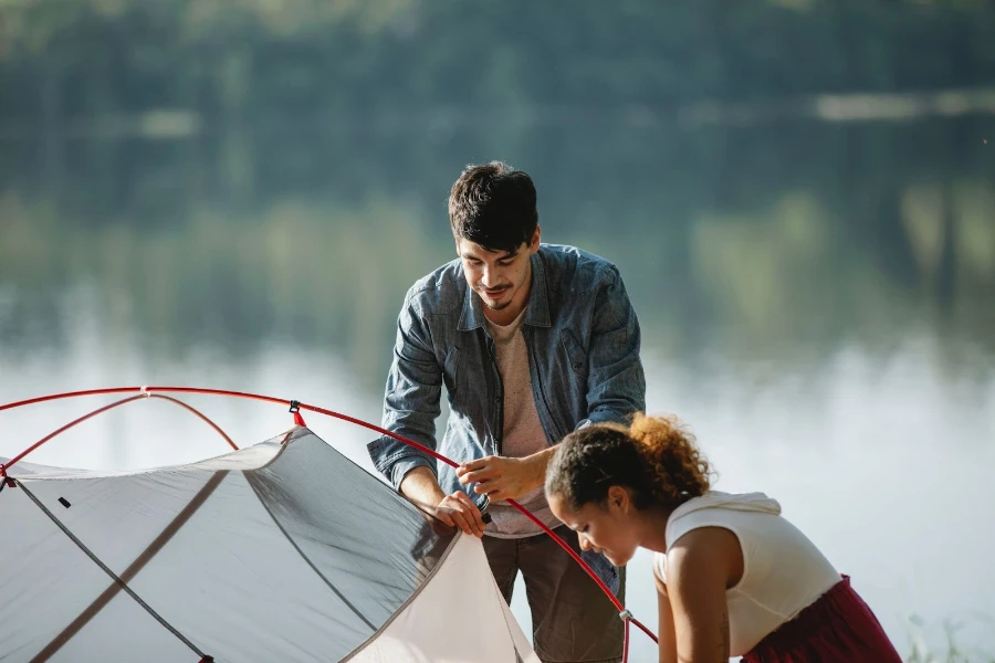 man and woman setting up tent