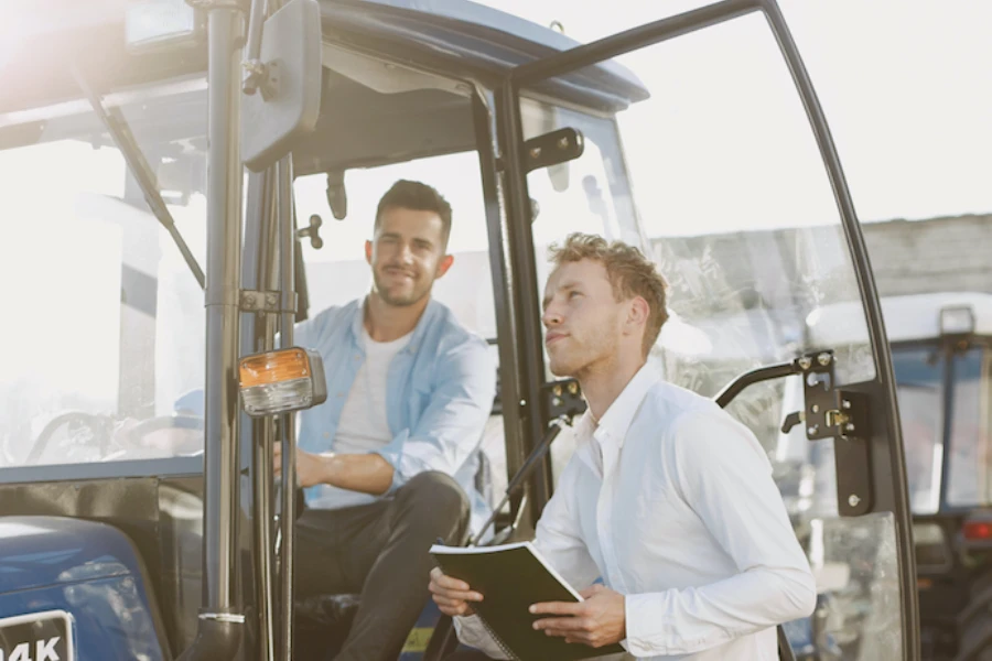 men inspecting a tractor cab