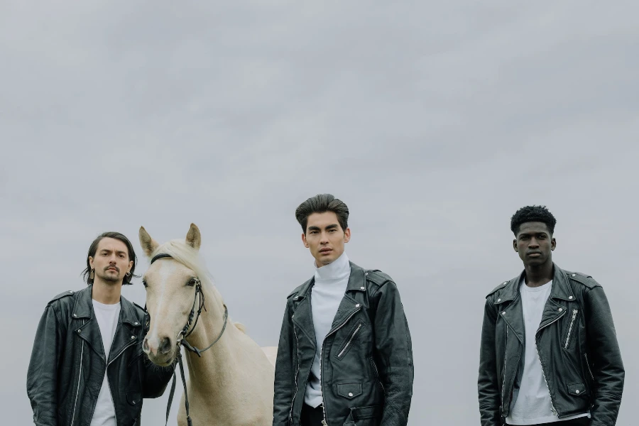 Hombres vestidos con chaquetas de cuero posando con un caballo