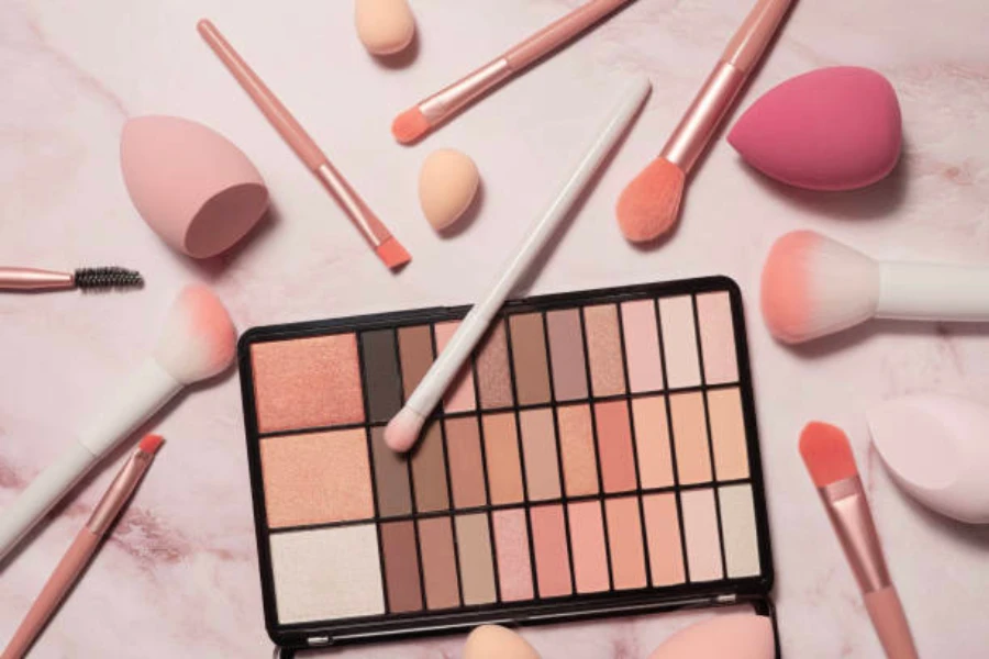 Palette de maquillage nude et rose avec plusieurs pinceaux de maquillage