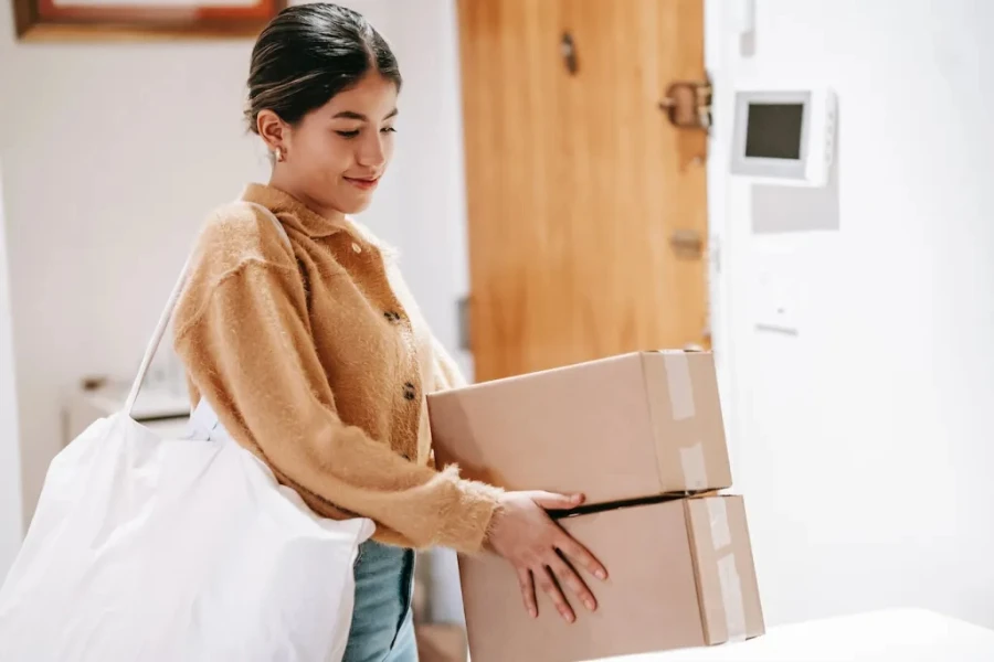 Femme souriante avec un sac à provisions et des marchandises emballées