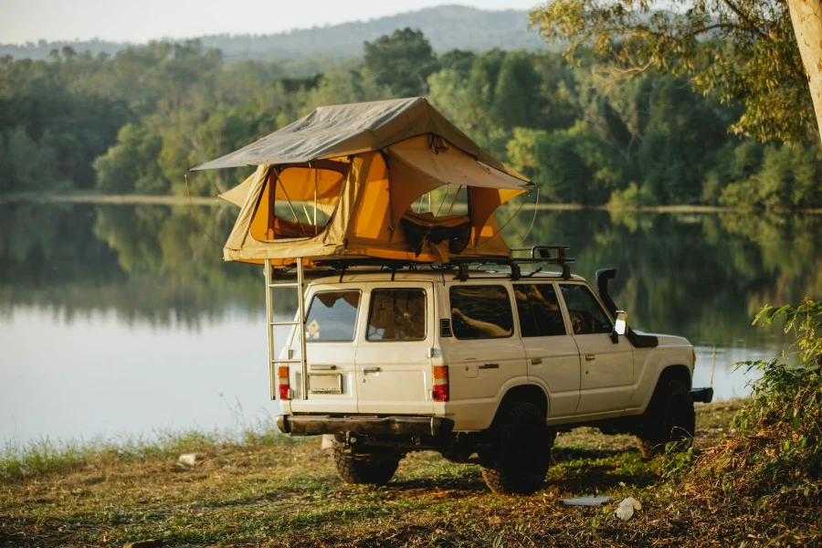 vehicle with roof tent by water