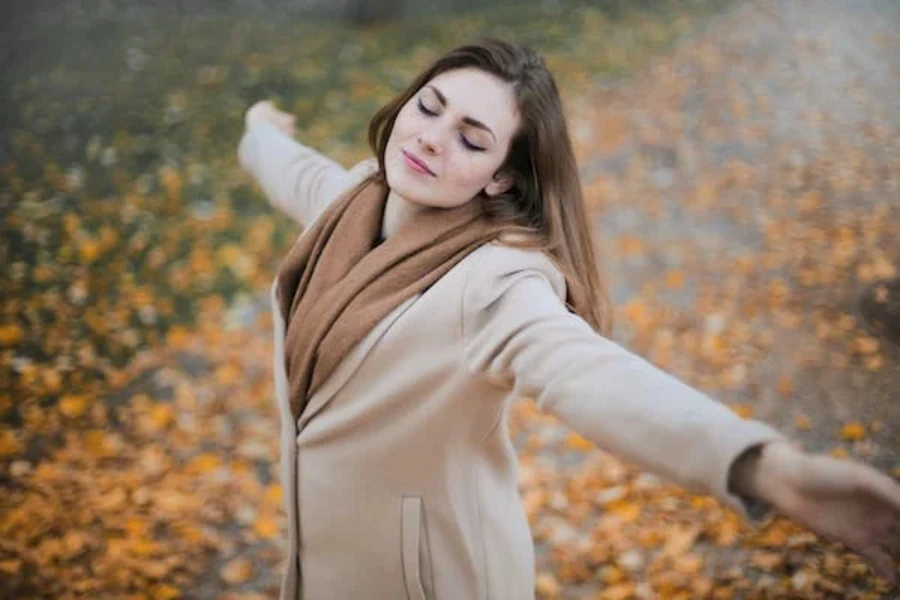 Woman in a beige long-sleeve coat for the autumn/winter season