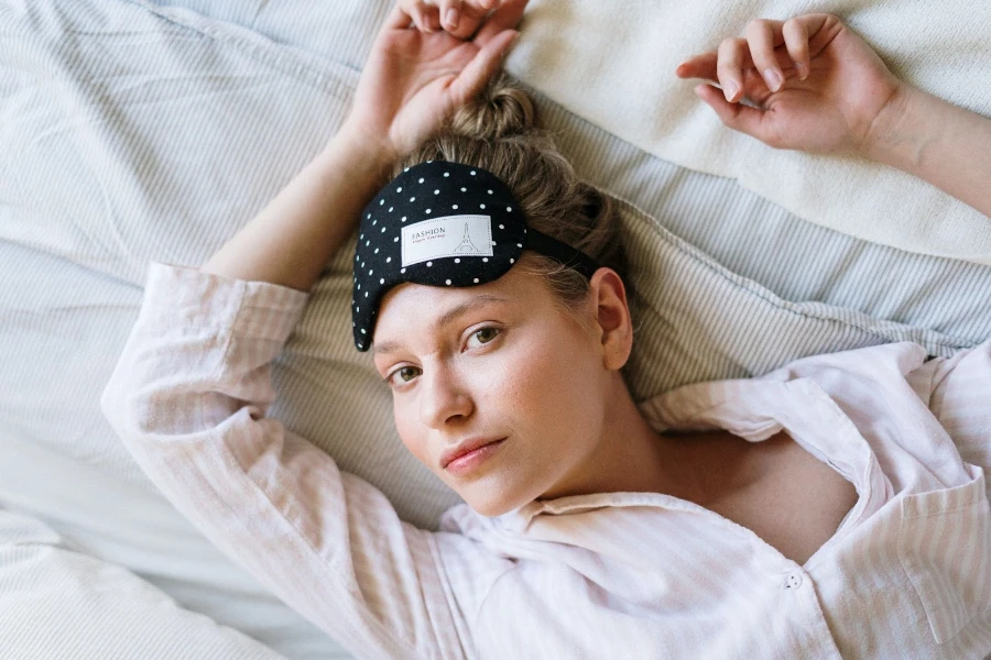 woman in bed with sleep mask on forehead