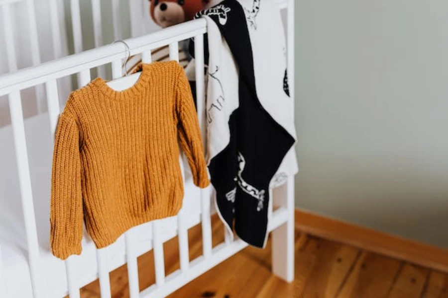 Un ensemble de vêtements pour bébés sur un lit d'enfant