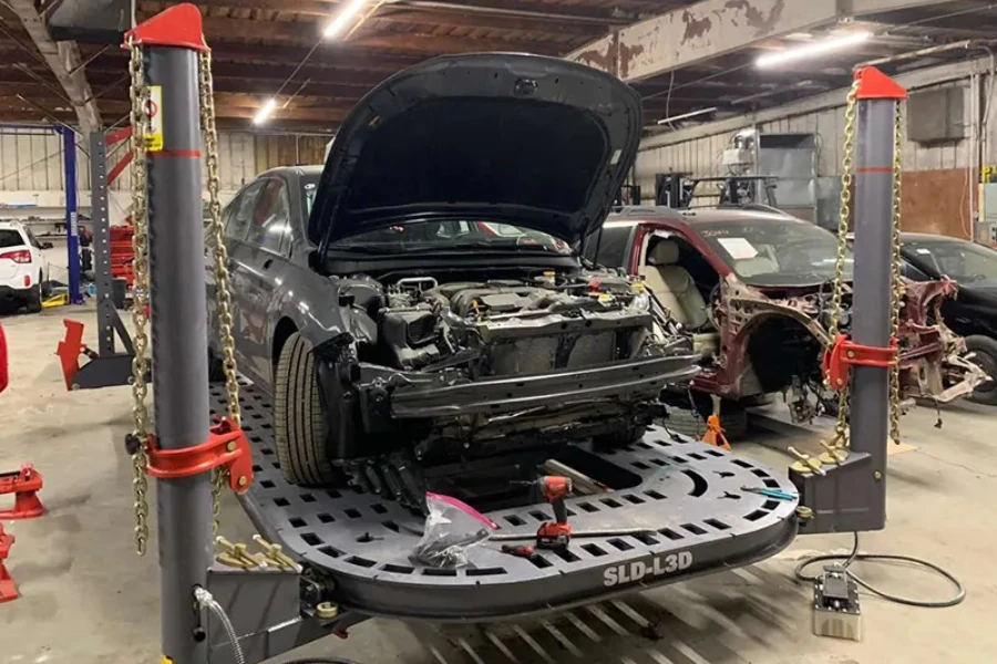 Mécanicien Vérifiant L'alignement De La Voiture Vérifiant Le Châssis à  L'aide D'une Lampe. Ingénieur Automobile Vérifiant Le Pneu Dans Le Centre  De Service De Maintenance. Travail Professionnel De Technicien Ou  D'ingénieur Pour