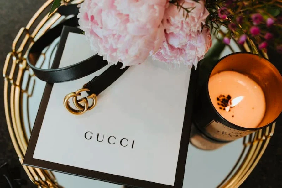 Um cinto Gucci sobre uma mesa com uma caixa Gucci