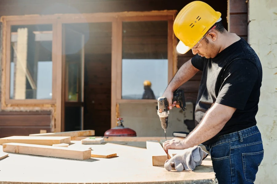 A man in a black T-shirt holding a drill machine