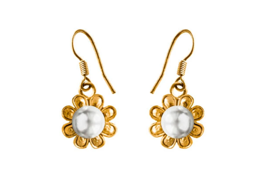 Une paire de boucles d'oreilles pendantes blanches et dorées