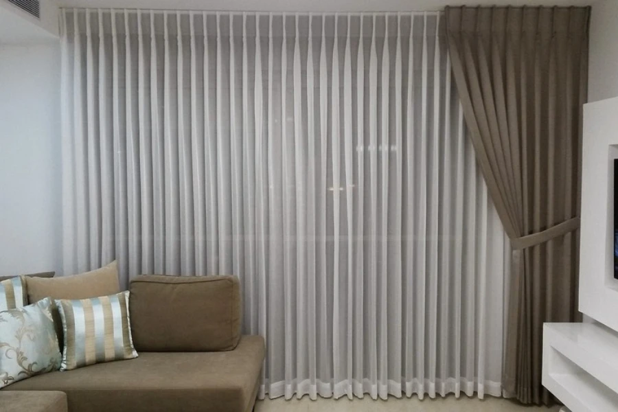 A window with full-length sheers and curtain