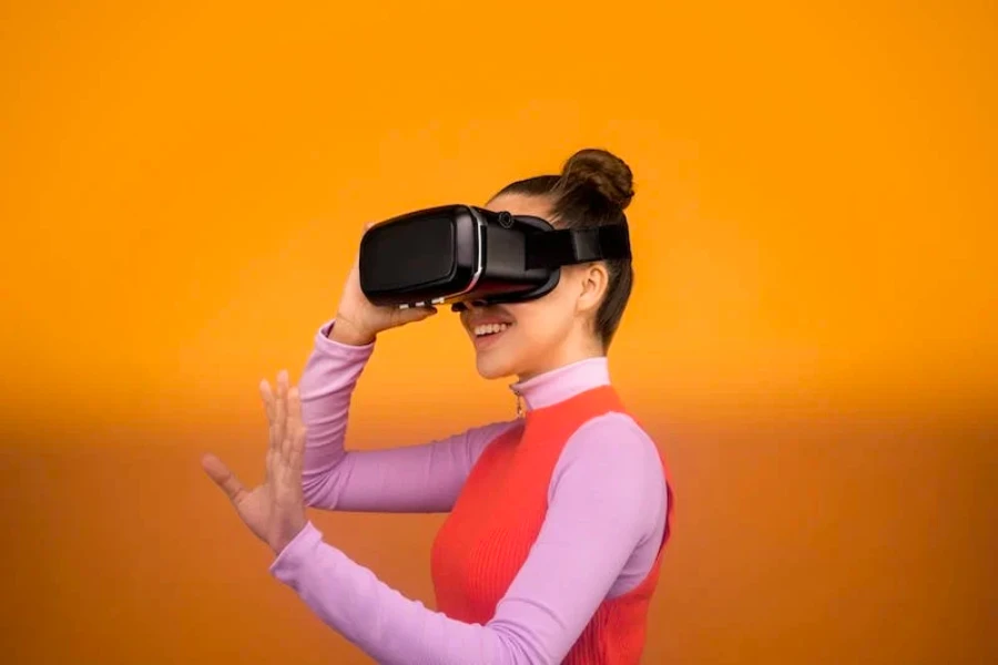 A woman wearing virtual reality goggles with an orange background
