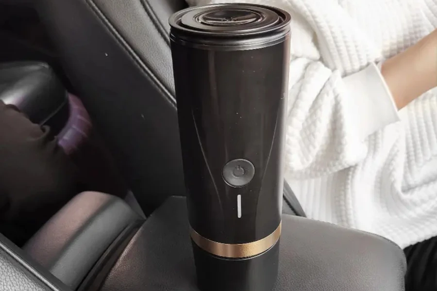 Black electronic portable coffee maker inside a vehicle