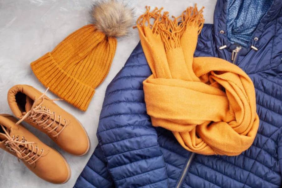 Coat, boots, hat, and scarf on a white fuzzy rug