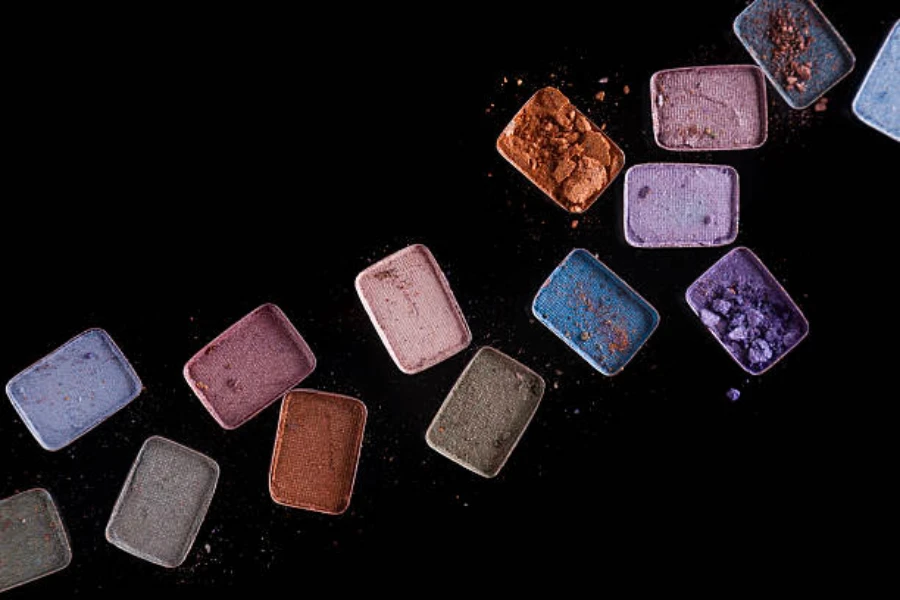 Different squares of eyeshadow laid across a black background