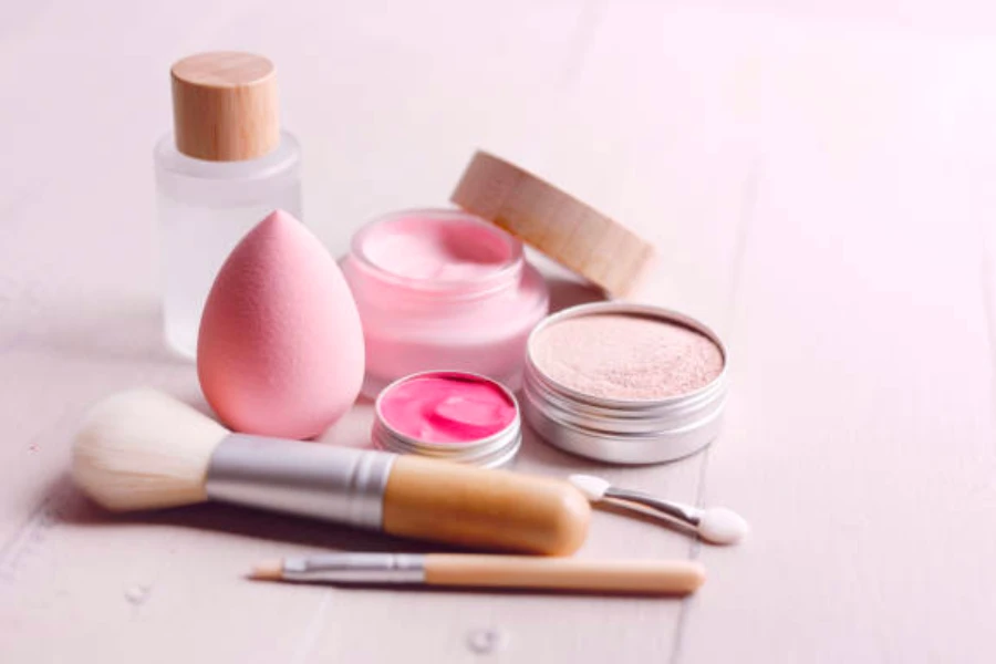 Different types of makeup and makeup brushes on a wooden table