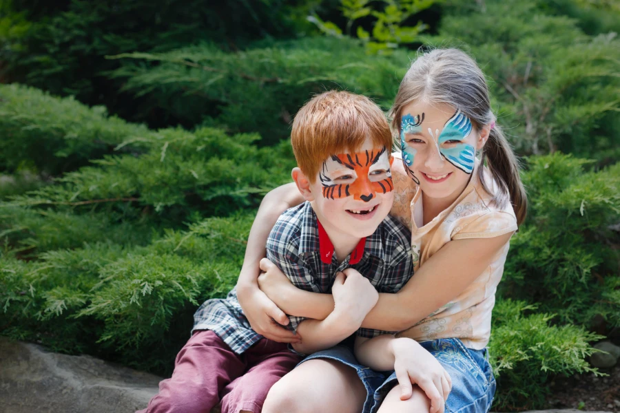 Heureux garçon et fille avec de la peinture faciale