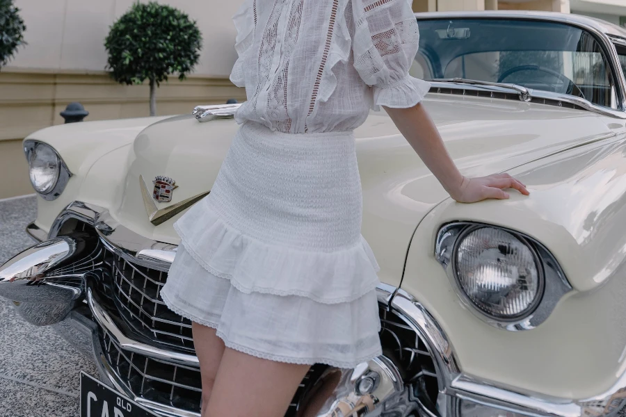 Lady posing on a car rocking a statement skirt
